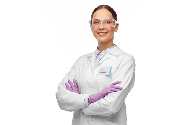 Smiling female scientist in goggles and gloves — Stock Photo, Image