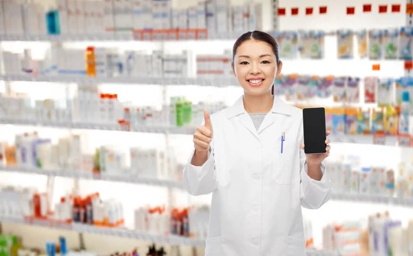 Asiático farmacéutico con teléfono muestra pulgares hasta —  Fotos de Stock