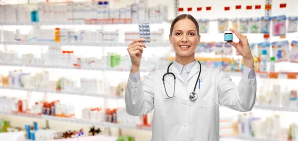 Sonriente médico femenino sosteniendo píldoras de medicina —  Fotos de Stock