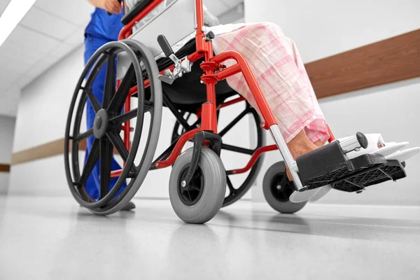 Zdravotní sestra se starším pacientem na invalidním vozíku na klinice — Stock fotografie