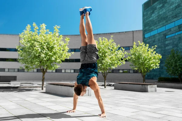 Jovem exercendo e fazendo handstand ao ar livre — Fotografia de Stock