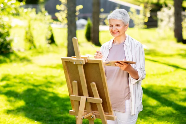 Seniorin mit Staffelei im Freien — Stockfoto