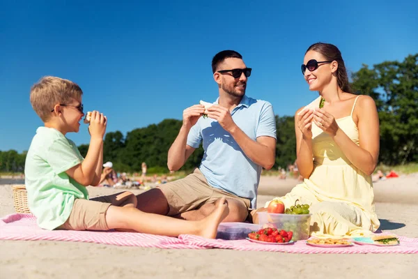 Famiglia felice facendo picnic sulla spiaggia estiva — Foto Stock