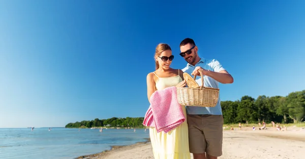 Szczęśliwa para z koszykiem piknikowym spacerująca po plaży — Zdjęcie stockowe