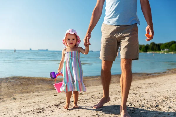 Baba küçük kızıyla kumsalda yürüyor. — Stok fotoğraf