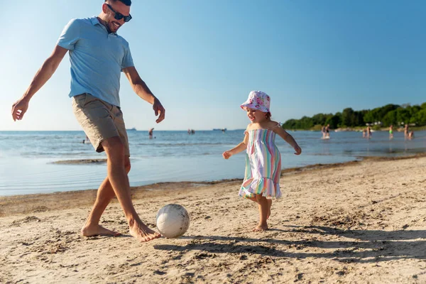 Boldog apa és lánya labdáznak a strandon — Stock Fotó