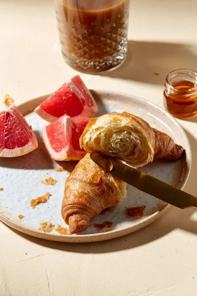 Verre de café, croissant et pamplemousse sur la table — Photo