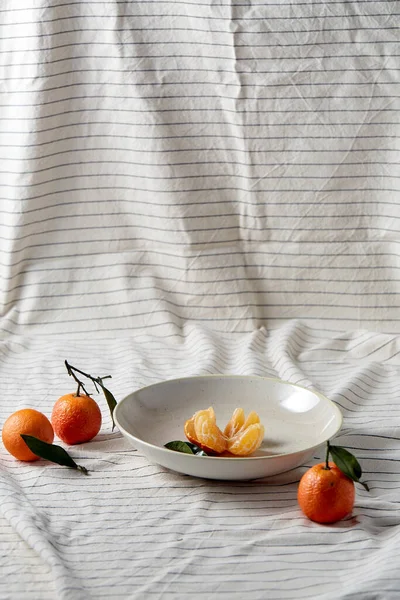 Nature morte con mandarini sul piatto sopra drappeggio — Foto Stock