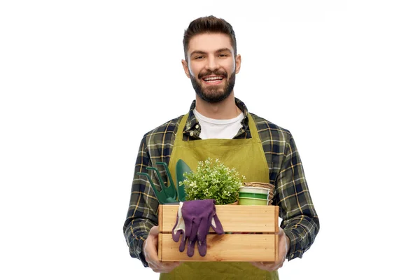 Glücklicher Gärtner oder Bauer mit Kiste mit Gartengeräten — Stockfoto