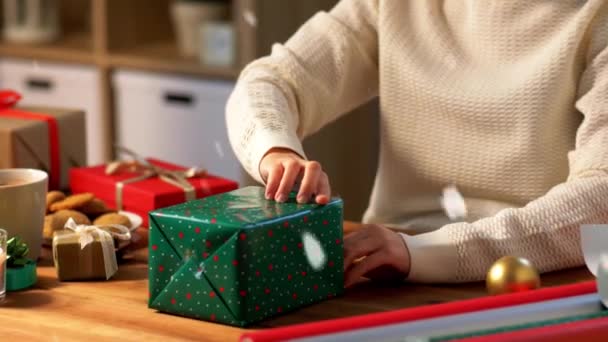 Γυναίκα περιτύλιγμα χριστουγεννιάτικο δώρο σε χαρτί στο σπίτι — Αρχείο Βίντεο