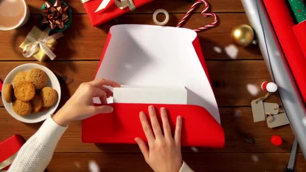 Woman wrapping christmas gift into paper at home — Stock Video