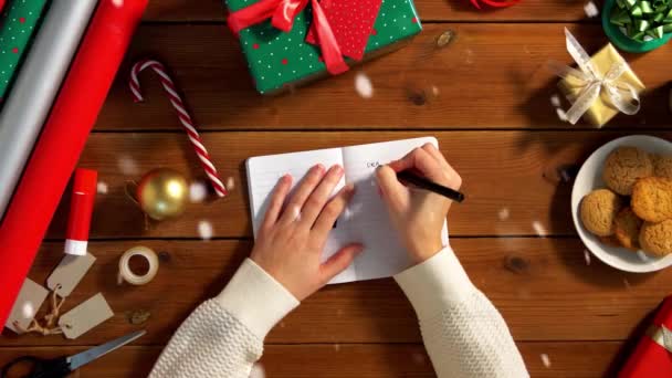 มือผู้หญิงเขียนจดหมายถึงซานต้าในสมุดบันทึก — วีดีโอสต็อก