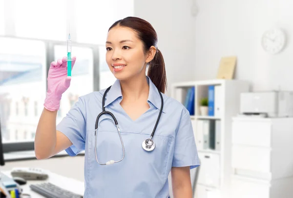 Glücklich asiatische Krankenschwester mit Spritze im Krankenhaus — Stockfoto