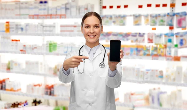 Szczęśliwa kobieta lekarz lub pielęgniarka ze smartfonem — Zdjęcie stockowe