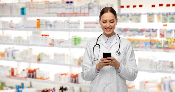 Feliz sonriente médico femenino con teléfono inteligente — Foto de Stock