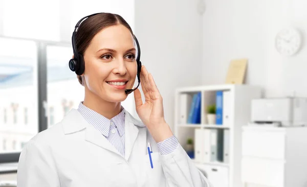 Sorridente médico feminino com fone de ouvido — Fotografia de Stock