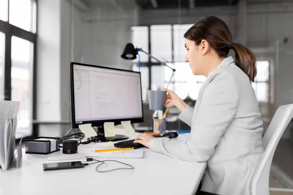 Podnikatelka s počítačem a kávou v kanceláři — Stock fotografie
