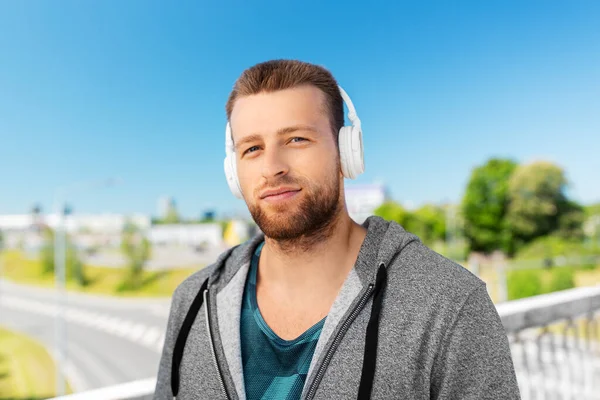 Mężczyzna w słuchawkach słuchanie muzyki na zewnątrz — Zdjęcie stockowe