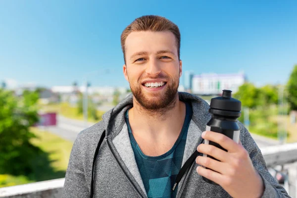 Happy young man with sports bottle — Stock Photo, Image