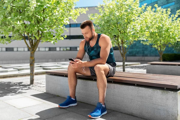 Young athlete man with earphones and smartphone — Stock Photo, Image