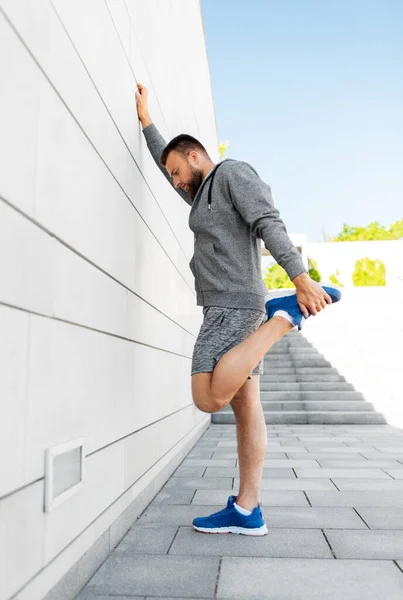 Muž protahování noha venku — Stock fotografie