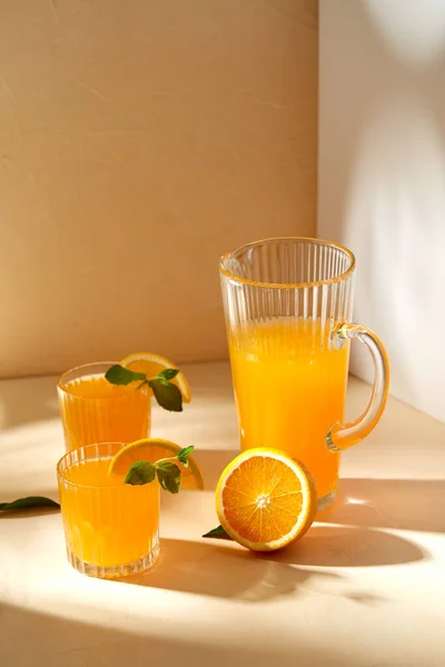 Vasos con zumo de naranja y menta sobre la mesa — Foto de Stock