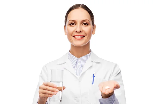 Médico fêmea com medicina e copo de água — Fotografia de Stock