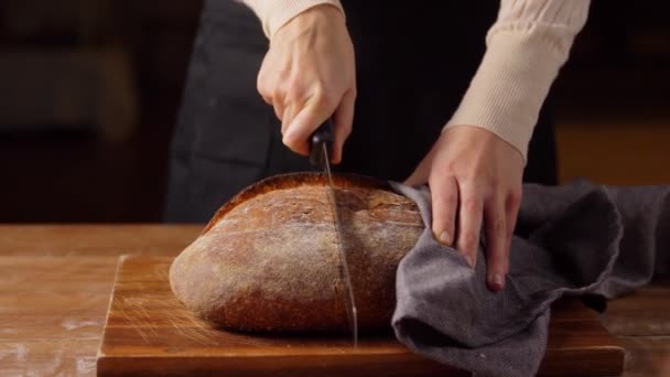 Żeński piekarz krojący chleb domowej roboty w piekarni — Wideo stockowe