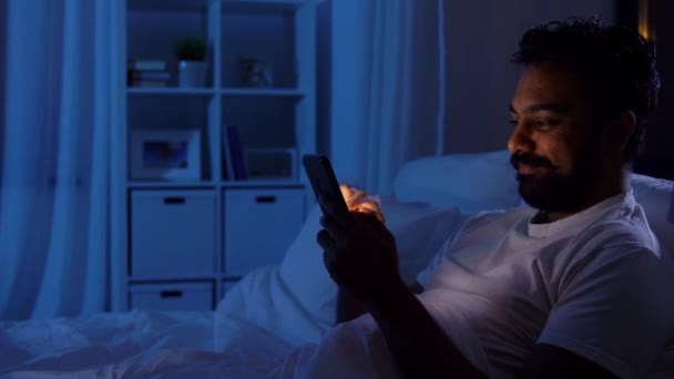 Indián s chytrým telefonem v posteli doma v noci — Stock video