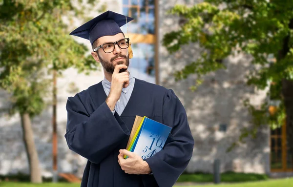 Doordachte afgestudeerde student of vrijgezel met boeken — Stockfoto