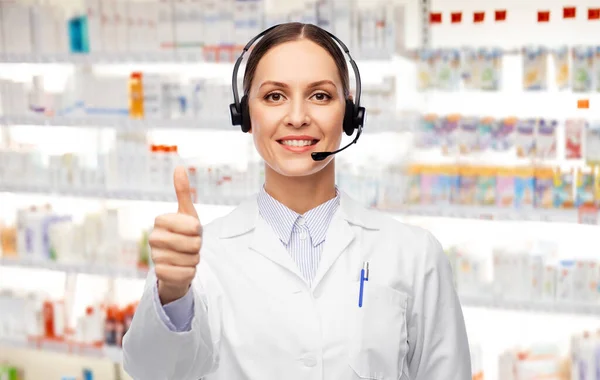 Χαμογελαστή γυναίκα γιατρός με ακουστικά στο φαρμακείο — Φωτογραφία Αρχείου