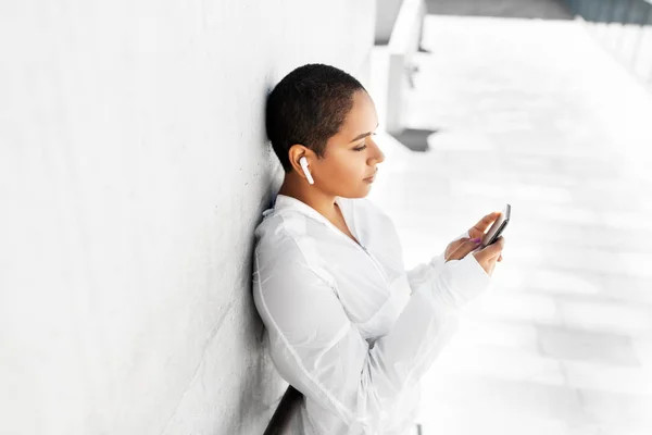 Африканская американка с наушниками и телефоном — стоковое фото