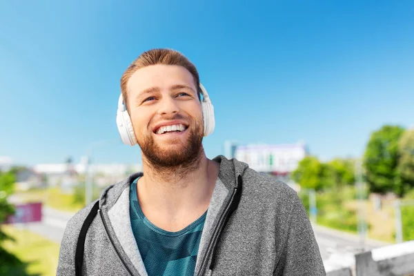 헤드폰을 끼고 밖에서 음악을 듣고 있는 남자 — 스톡 사진