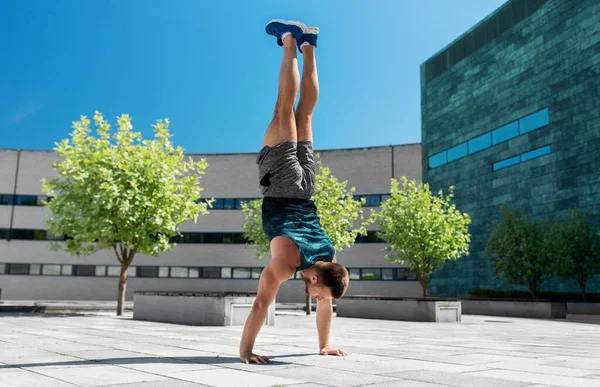 Jovem exercendo e fazendo handstand ao ar livre — Fotografia de Stock