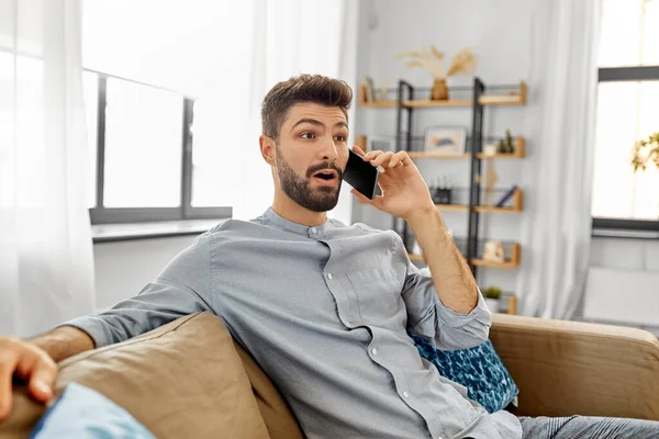 Uomo che chiama su smartphone a casa — Foto Stock