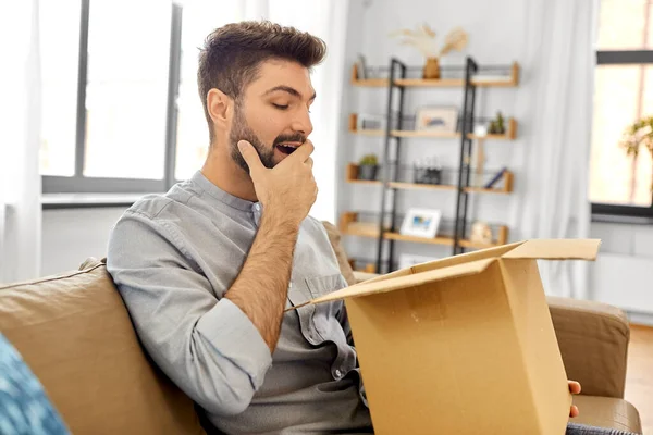 Heureux homme souriant avec boîte de colis ouverte à la maison — Photo