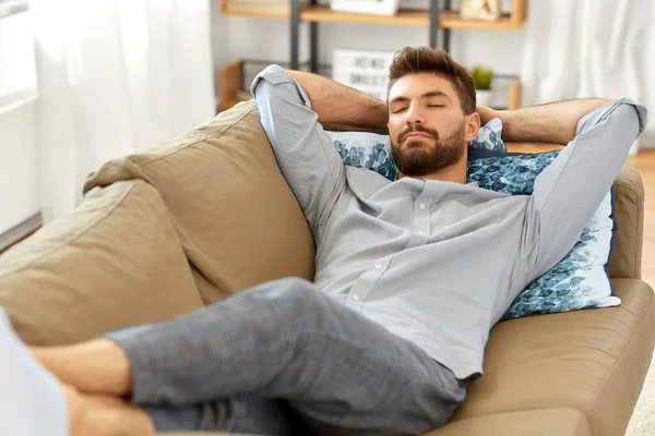 Fiatal férfi alszik kanapén otthon — Stock Fotó