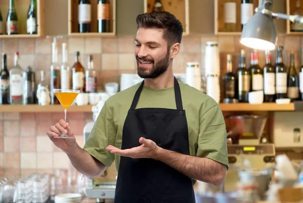 Heureux barman dans tablier avec verre de cocktail — Photo