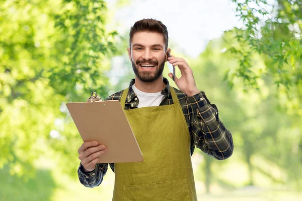 Jardinero masculino con portapapeles llamando en el teléfono inteligente —  Fotos de Stock