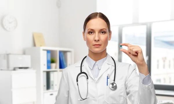 Médico feminino segurando pílula de medicina no hospital — Fotografia de Stock