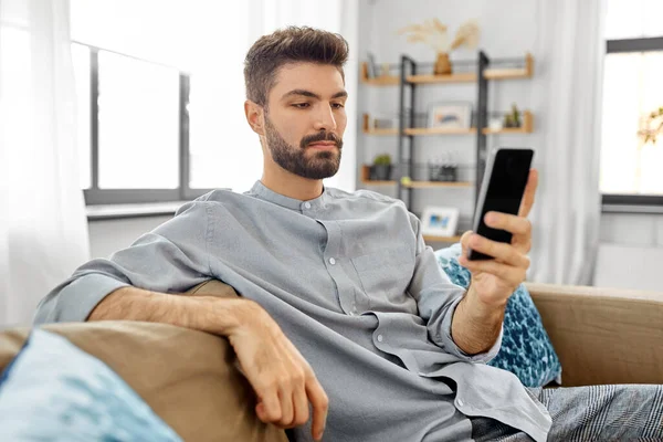 Junger Mann mit Smartphone zu Hause — Stockfoto
