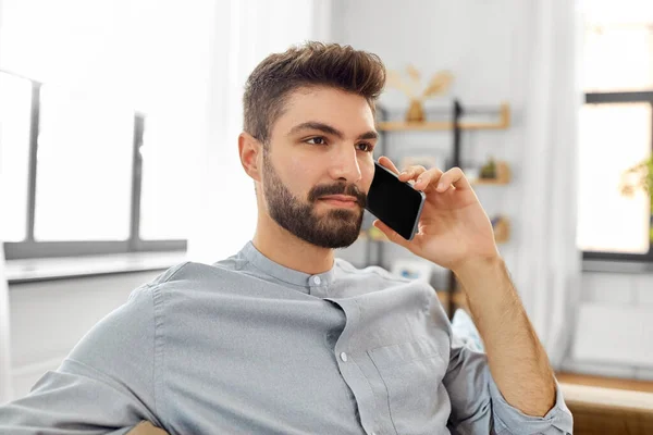 Homem chamando no smartphone em casa — Fotografia de Stock