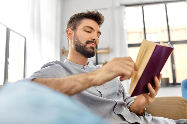 Hombre leyendo libro en casa — Foto de Stock