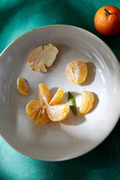 Bodegón con mandarinas peladas en placas —  Fotos de Stock