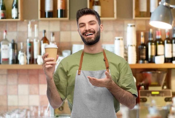 Gelukkig glimlachende barman in schort met afhaalkoffie — Stockfoto