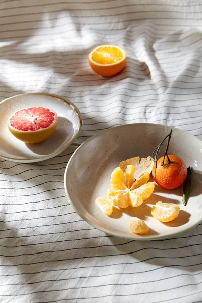 Stilleben med mandariner och grapefrukt på tallriken — Stockfoto