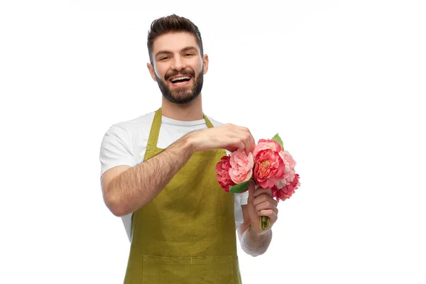 Smiling male gardener with bunch of peony flowers Royalty Free Stock Photos