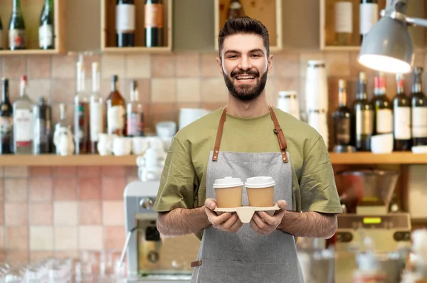 Feliz sorridente barman em avental com takeaway café — Fotografia de Stock