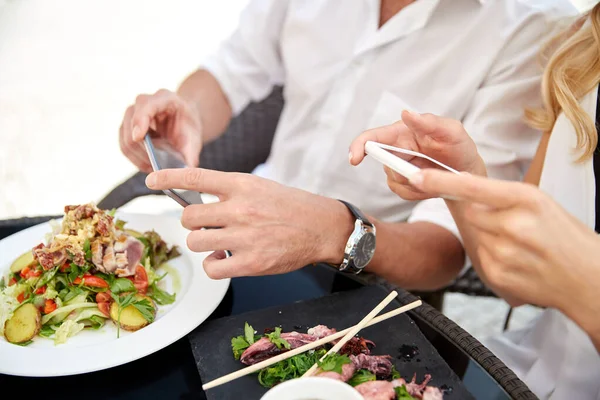 Casal com smatphones fotografar alimentos — Fotografia de Stock