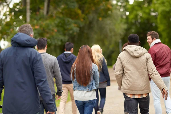 Gelukkige vrienden wandelen langs het herfstpark — Stockfoto